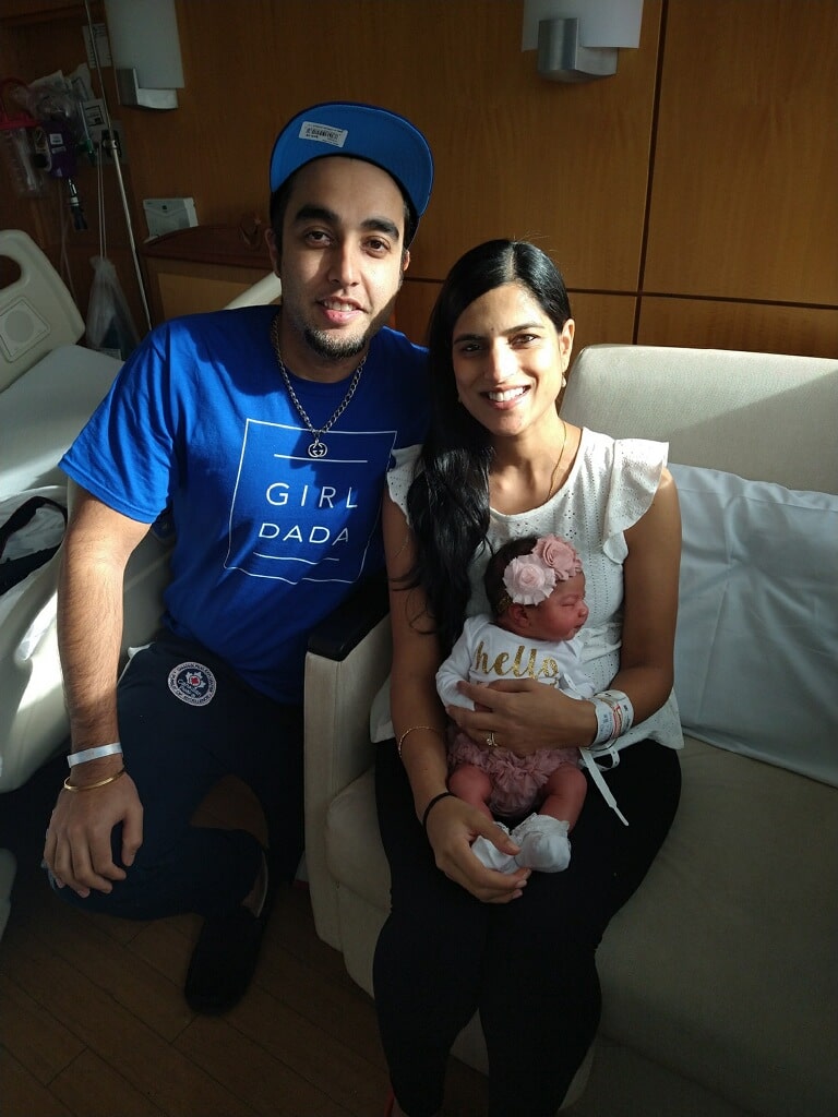 Mother and father pose with newborn baby