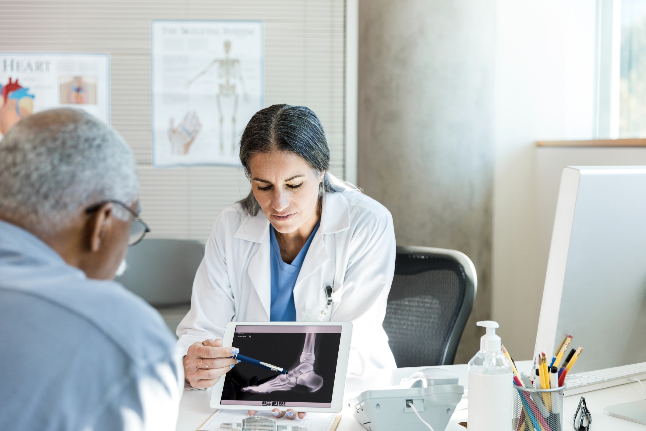 Podiatrist showing a patient an x ray of a foot.