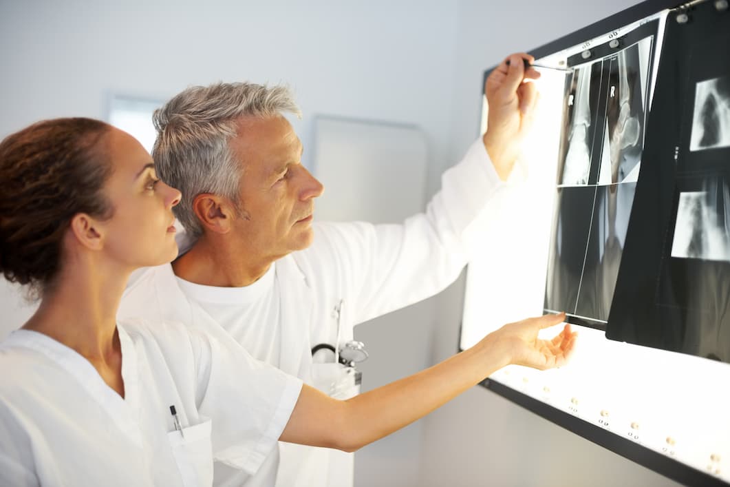 Orthopedic doctor looking at x-rays of orthopedic patient's knee.